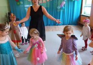 Dzieci w strojach karnawałowych tańczą w czasie balu