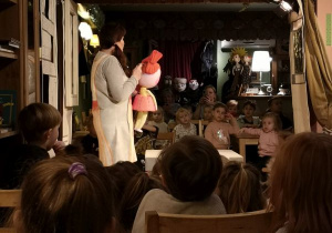 Aktorka stoi na scenie i prezentuje lalkę, która brała udział w przedstawieniu