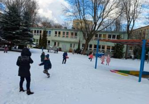 Zdjęcie przedstawia dzieci w czasie zabaw ruchowych w ogrodzie zimą