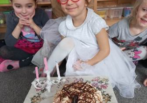 Jubilatka z koroną na głowie pozuje do pamiątkowego zdjęcia z tortem