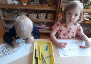 chłopiec i dziewczynka kolorują obrazki inspirowane aktywnością Pieta Mondriana