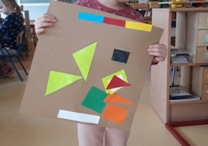 dziewczynka prezentuje swoją kompozycję z figur geometrycznych