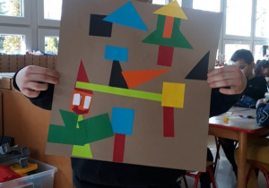 chłopiec prezentuje swoją kompozycję z figur geometrycznych