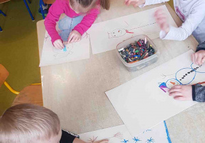 Dzieci rysują bałwana według instrukcji podanej w wierszu