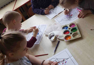 Dzieci malują farbami karnawałowego klauna