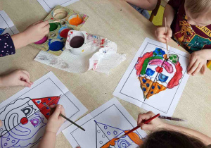 Dzieci malują farbami maskę klauna
