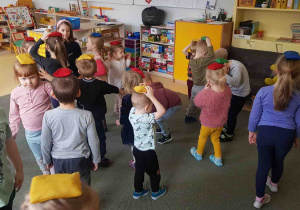 Dzieci poruszają się po sali z woreczkiem gimnastycznym na głowie