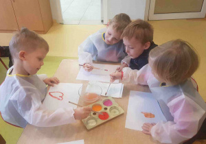 Dzieci malują farbami serduszka według własnego pomysłu