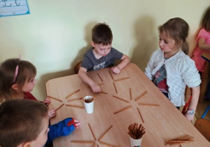 Dzieci układają wzory zaproponowane przez nauczyciela z konkretnie odliczonej ilości paluszków
