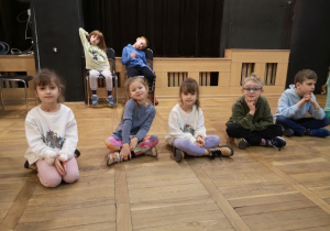 Dzieci siedzą i słuchają informacji dotyczących tańców