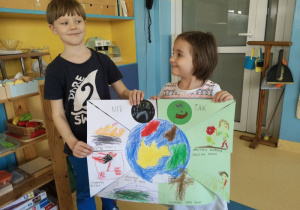 Chłopiec i dziewczynka prezentują wykonany przez siebie plakat