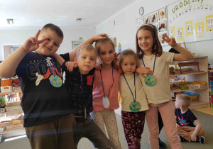 Dzieci pokazują medale na Dzień Ziemi