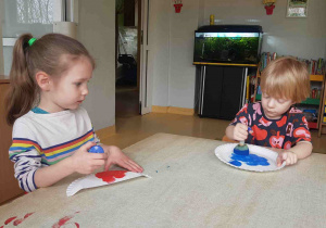 Dzieci stemplują papierowe talerzyki i przygotowują elementy pracy plastycznej
