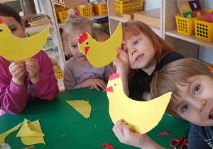 Dzieci pokazują żółte kurki wycięte z filcu