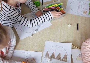 Dzieci rzucają kostą i rysują wzór na pisance zgodnie z poleceniem