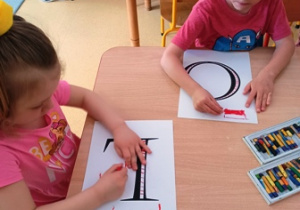 Dzieci ozdabiają litery składające się na napis "Polska"