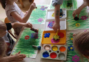 Dziewczynki stemplują farbami kwiaty