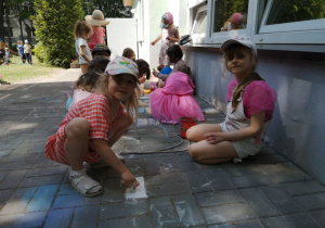Dziewczynki rysują kredami na tarasie