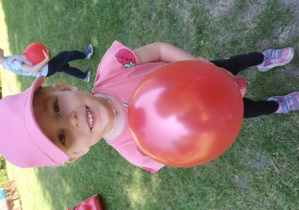 Tosia pozuje do zdjęcia ze swoim czerwonym balonem
