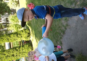 Maciuś wykorzystuje pompkę do nadmuchania niebieskiego balonu