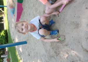 Chłopiec bawi się w piasku