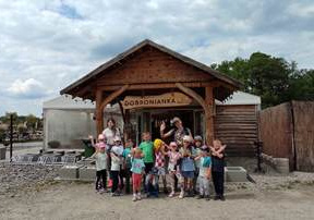 Grupa dzieci pozuje do pamiątkowego zdjęcia z wycieczki