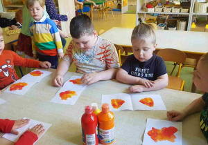 Dzieci odbijają na kartce papieru ogniste kolory
