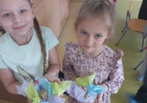 Dwie dziewczynki prezentują stworzone przez siebie plastelinowo-makaronowe ślimaki