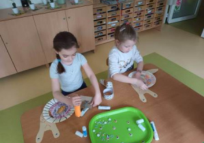 Dwie dziewczynki w czasie wykonywania tematycznej pracy plastycznej dotyczącej ślimaków