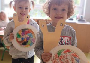 Chłopiec i dziewczynka prezentują wykonaną przez siebie prace plastyczną pt. "Ślimak"