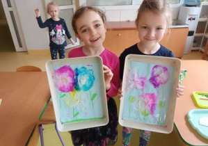 Nela i Hania prezentują wykonane przez siebie prace plastyczne pt. "Kompozycja kwiatowa"