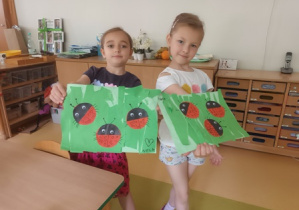 Hania i Nela prezentują gotowe prace plastyczne przedstawiające biedronki
