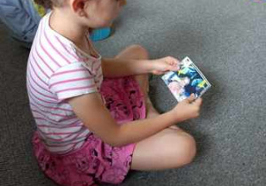 Dziewczynka ogląda zdjęcia Ali z poszczególnych etapów życia