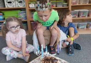 Franio zdmuchuje świeczki z urodzinowego tortu