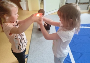Dziewczynki w czasie ćwiczenia ciszy, przekazują sobie świecę