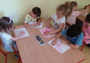 Dzieci w trakcie zabawy plastycznej - kreślenia wiązki pastelami od punktu