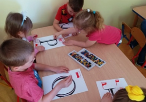 Dzieci w trakcie ozdabiania napisu "Polska"