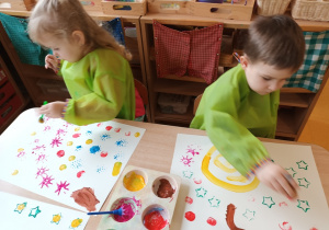 Dzieci podejmują działania z wykorzystaniem farb.