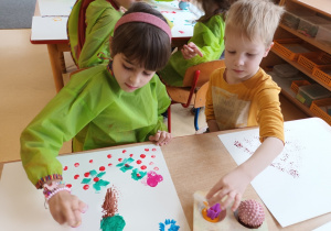 Dzieci podczas malowania z wykorzystaniem gąbek.