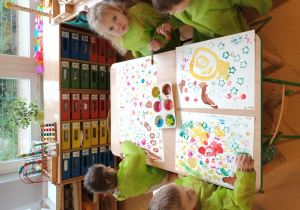 Dzieci w skupieniu podczas działań z farbami.