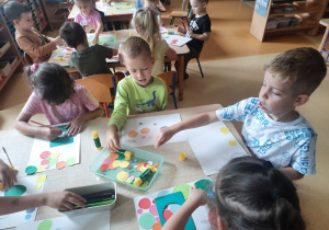 Dzieci wykonujące prace plastyczną z okazji dnia kropki