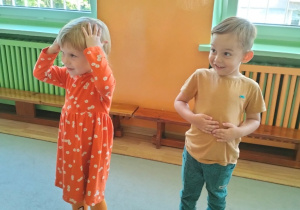 dzieci wskazują poszczególne częsci ciała podczas zabawy ruchowej