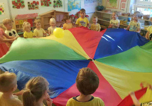 Dzieci podczas zabawy z chustą animacyjną i balonem