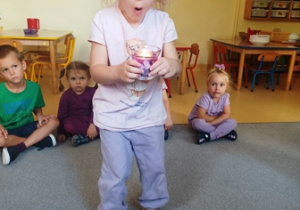 Julia zdmuchuje fioletową świecę