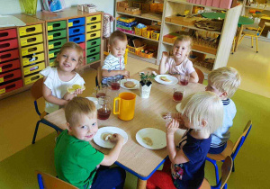 Dzieci siedzą przy stole podczas śniadania