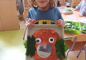 Chłopiec prezentuje zrobioną przez siebie pracę plastyczną pt. "Sowa"
