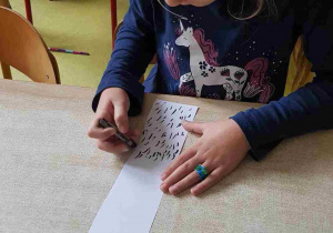 Dziewczynka rysuje pień brzozy