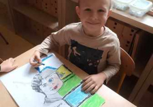Chłopiec domalowuje drugą część portretu Marii Montessori