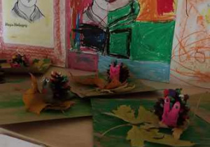 Wystawa dzieci przedstawiająca ślimaki zrobione z wykorzystaniem plasteliny, liści oraz szyszek