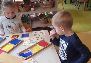 Dzieci układają obrazek z figur konstrukcyjnych